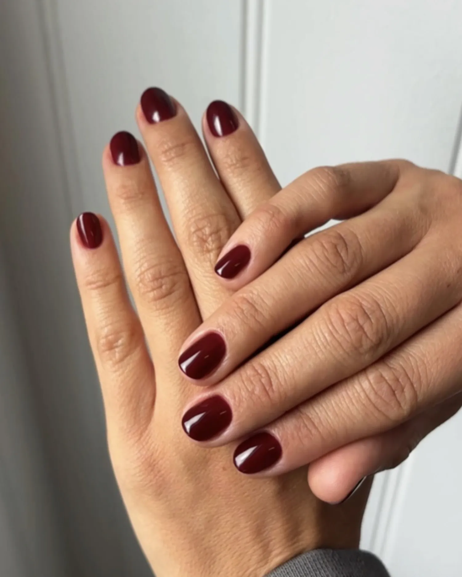 Hands with nails painted in a polished dark shade