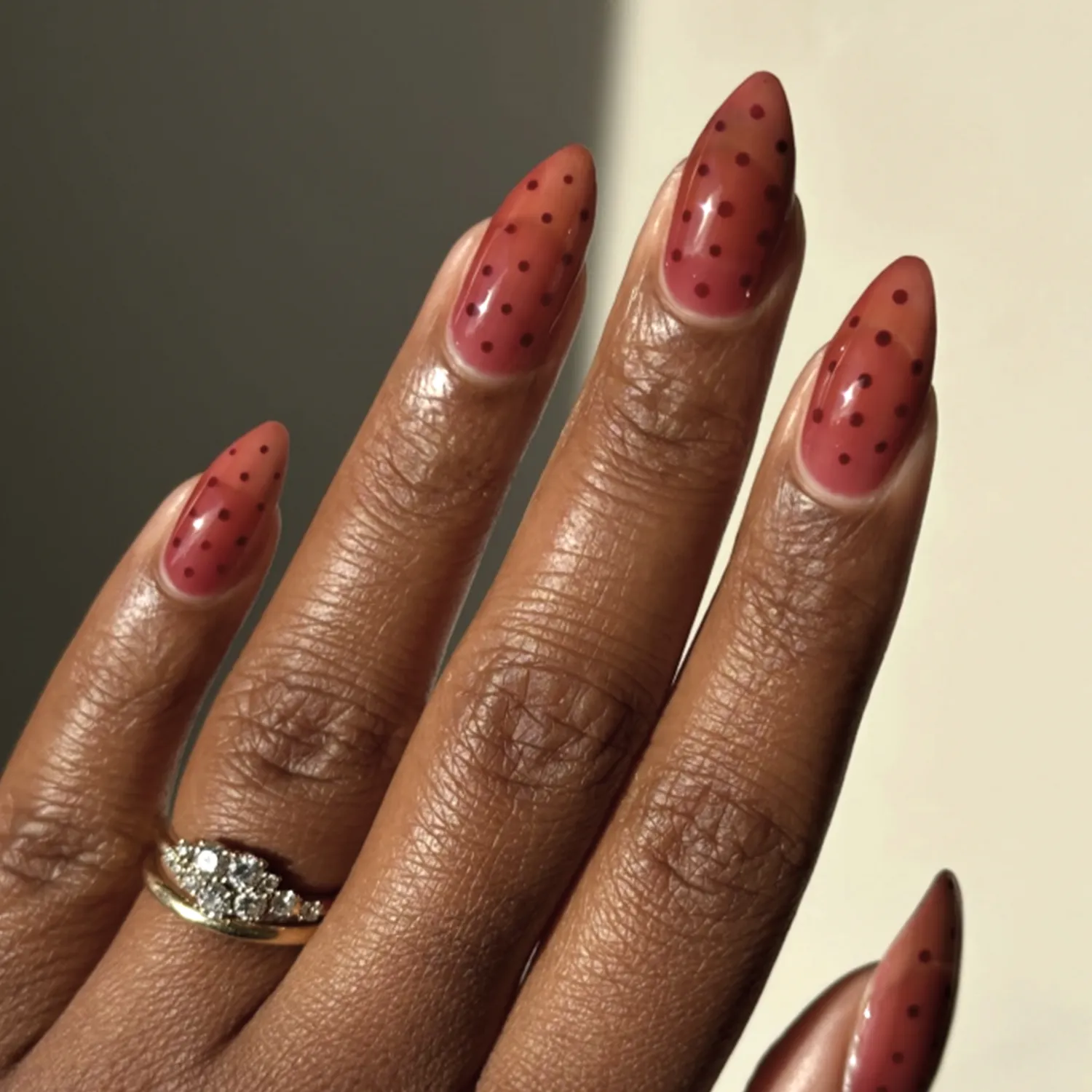 Hand with long almondshaped nails featuring a polished design