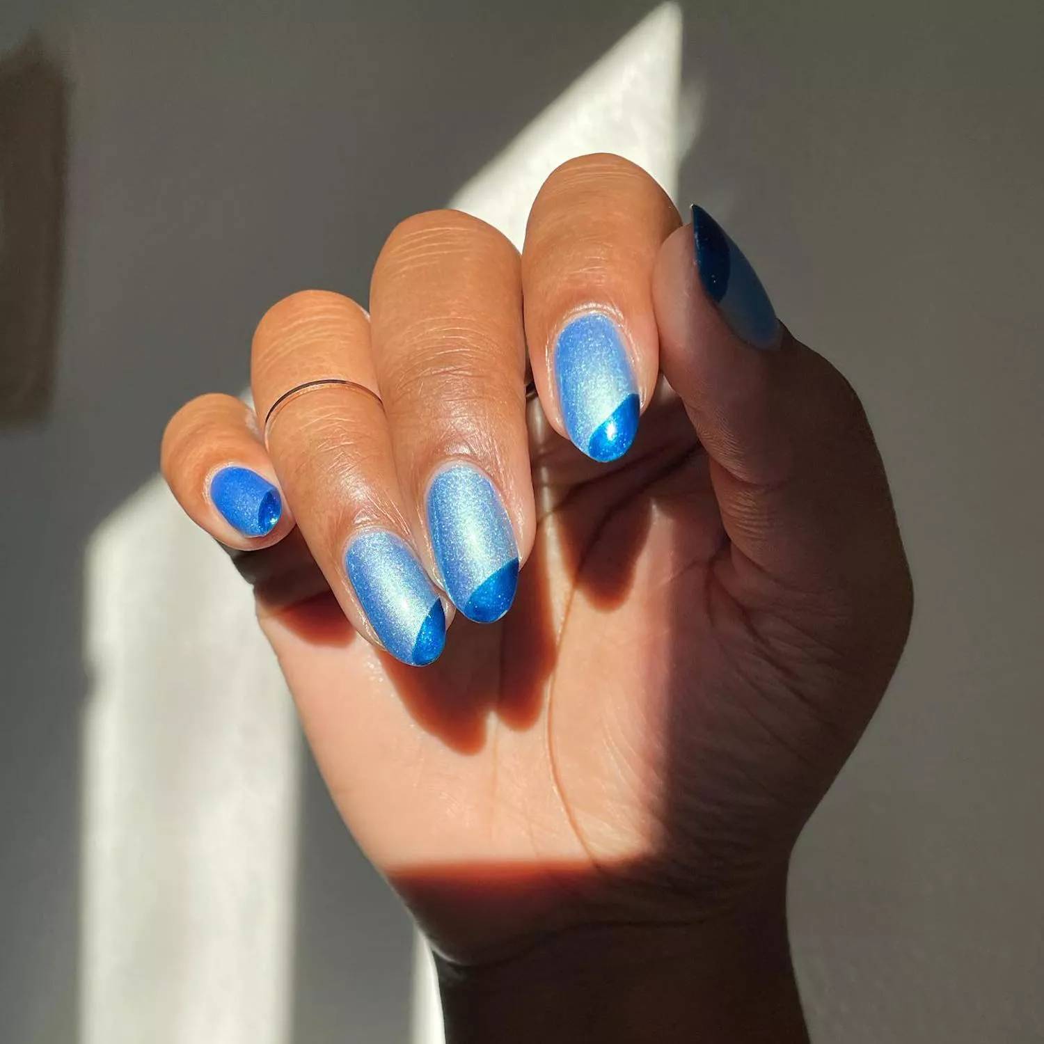 Light blue metallic nails with dark blue metallic diagonal tips