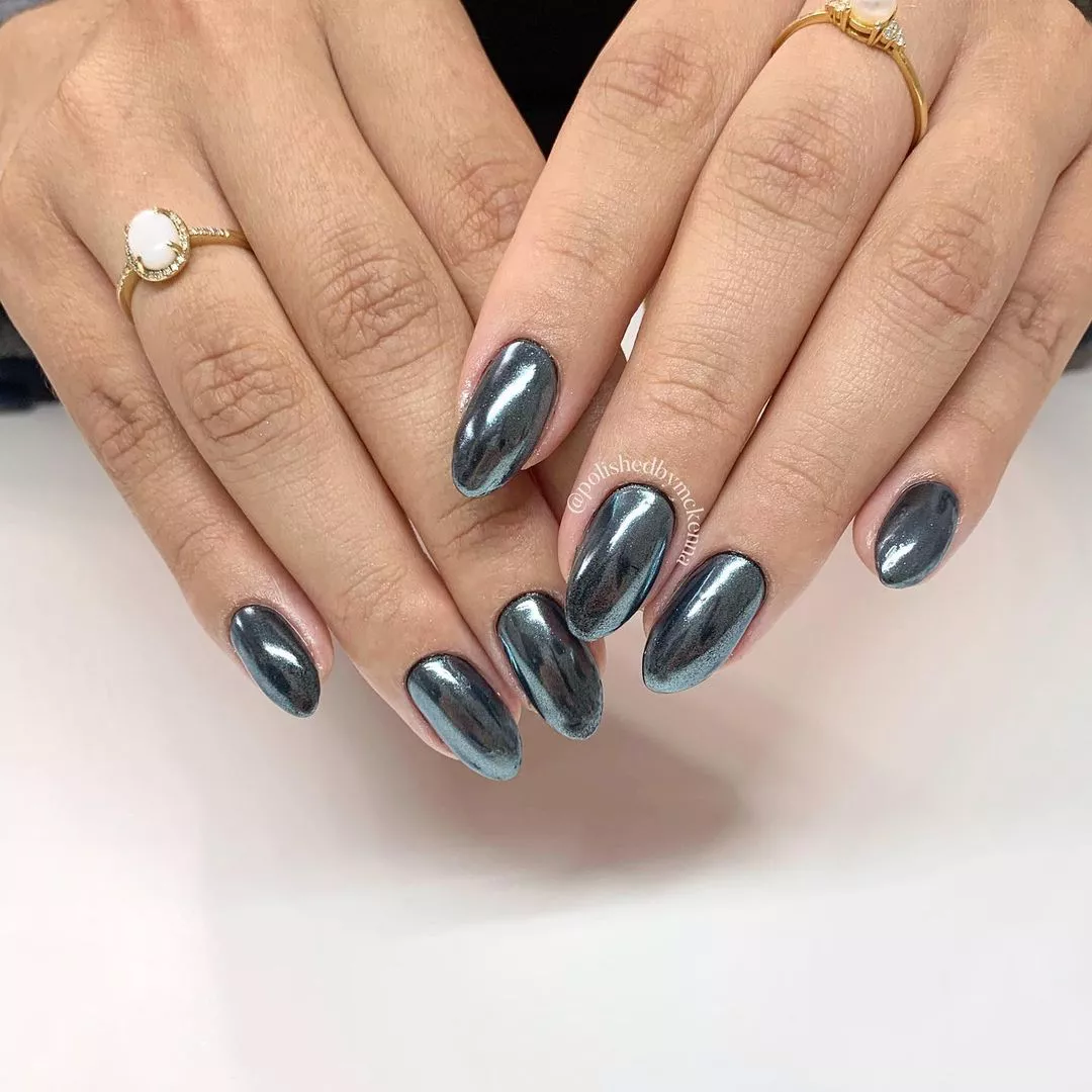 Hands with neatly manicured nails and metallic polish wearing two rings
