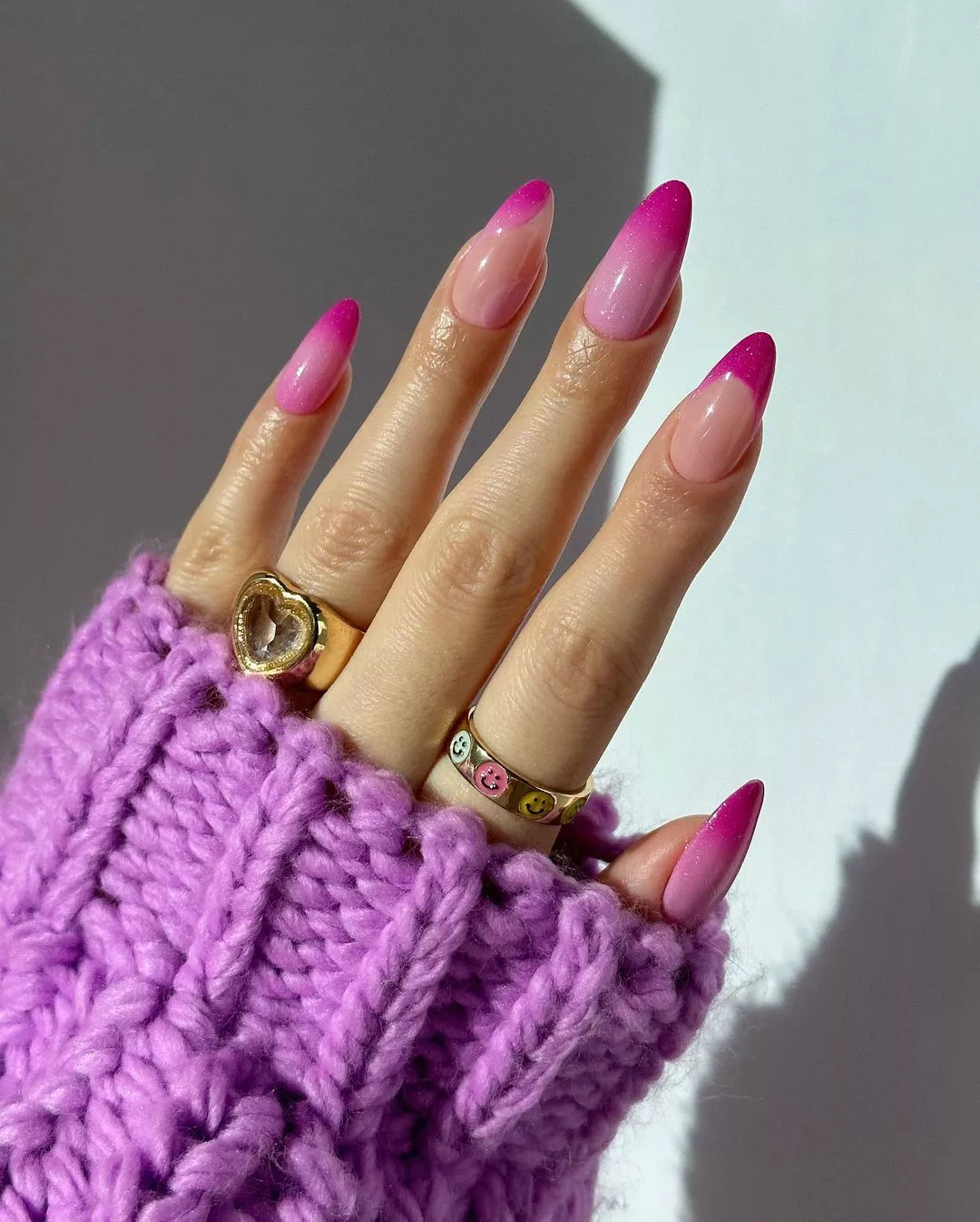 Person showing off their pink French tip nails, which feature gradient ombre accent nails