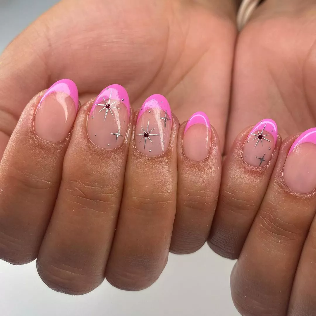 A French manicure with hot pink tips and star accents