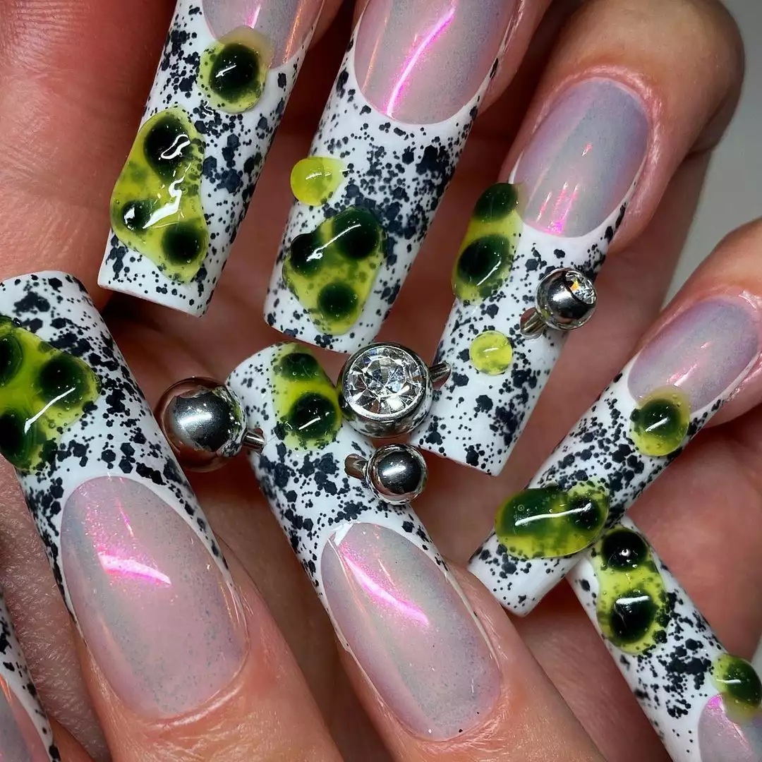 Long, square-shaped nails that have a chrome base and long French tips with slime and piercings