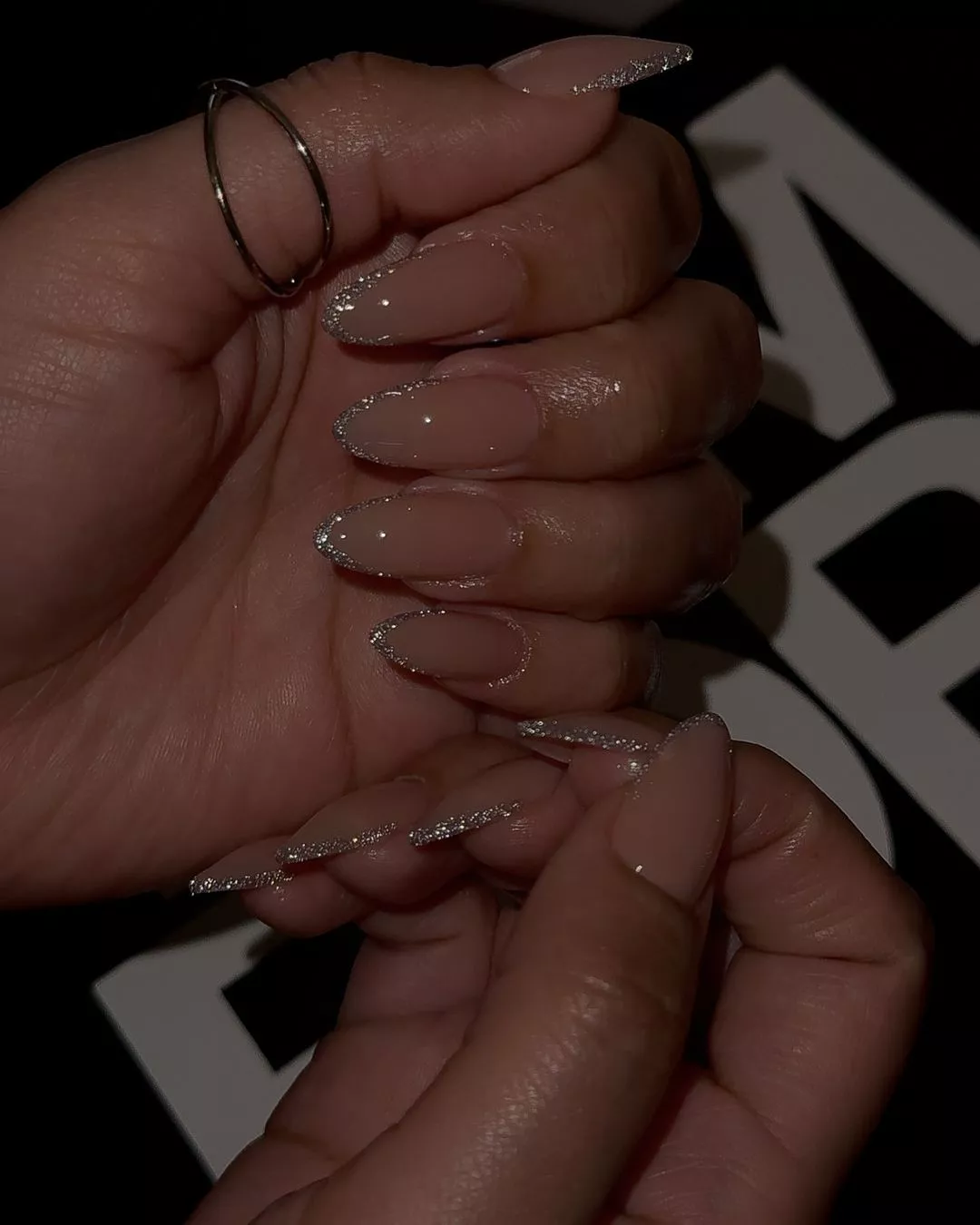 Closeup of hands showing nails with glossy metallic French tips