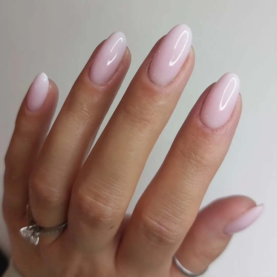 A hand with manicured nails featuring a smooth and glossy finish