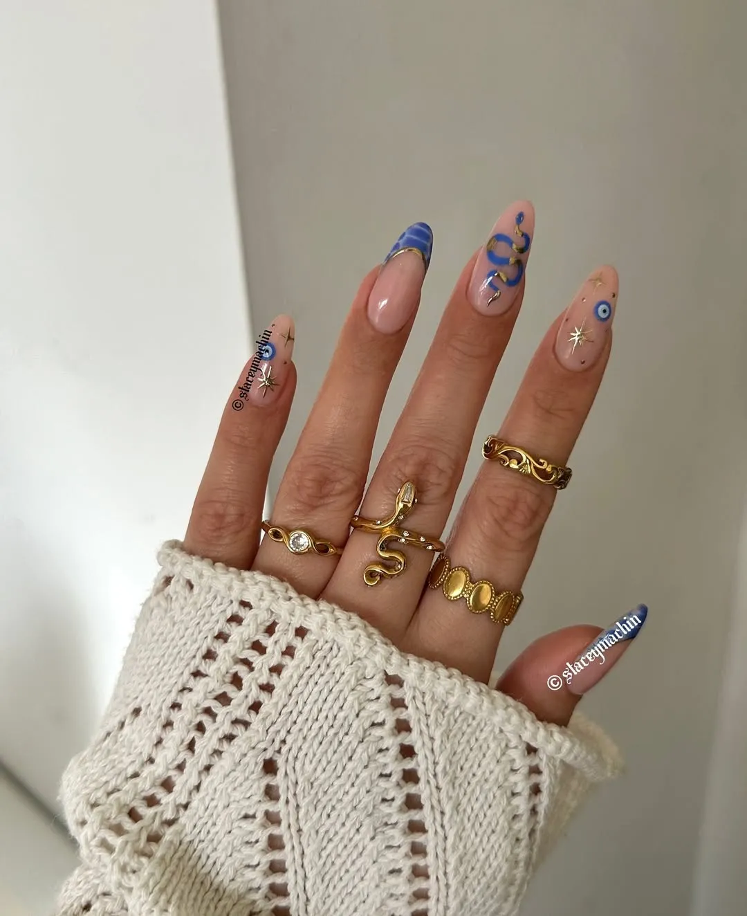 A womans hand wearing rings and showcasing decorative long nails