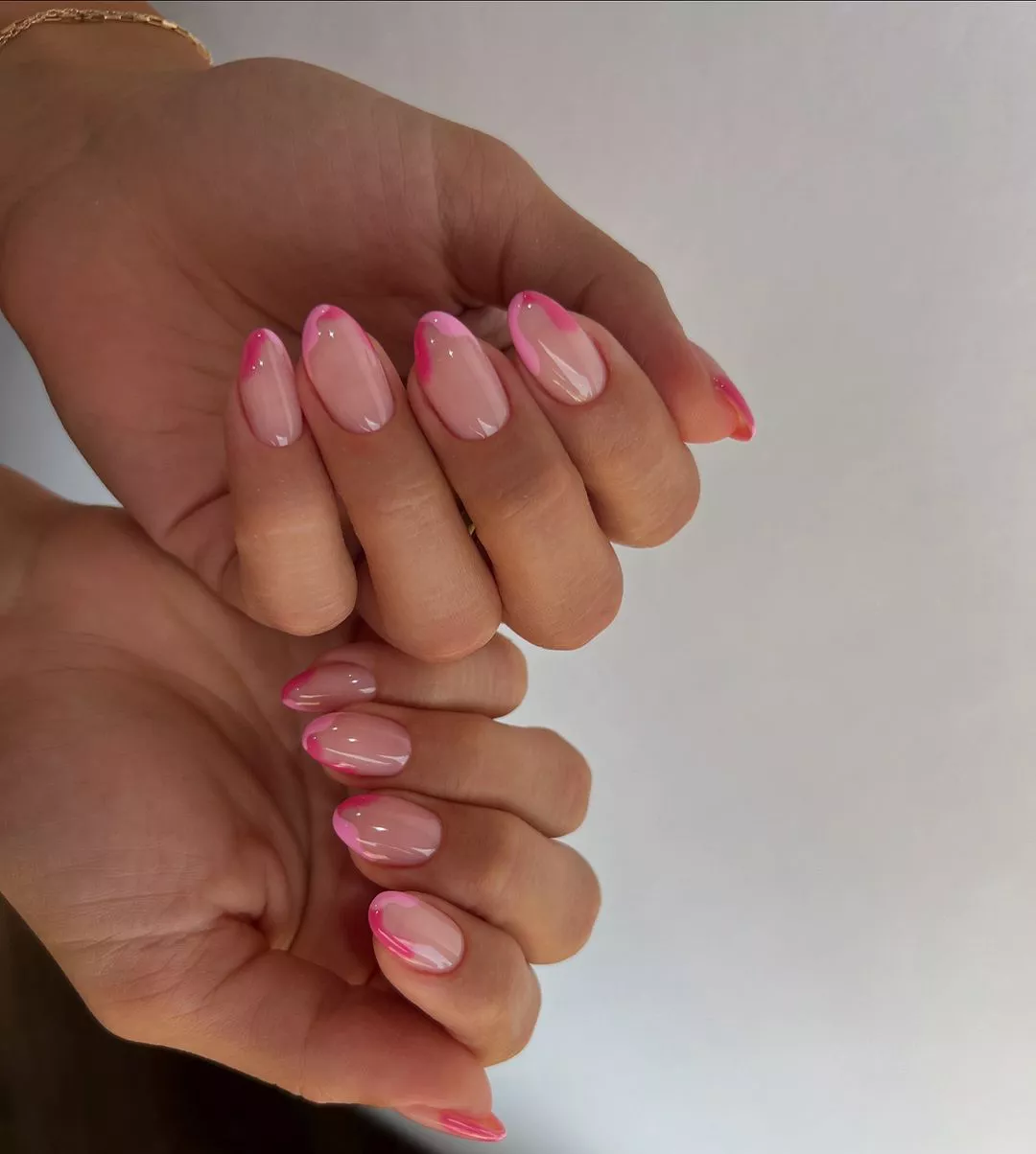 Person shows off their high-gloss pink French manicure, which has two tones on each nail