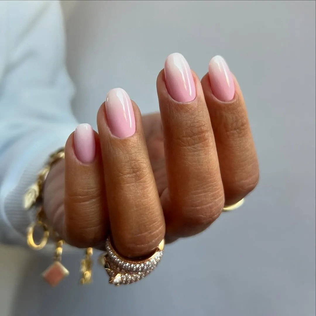 A hand with manicured nails shown with accessories like a bracelet and ring