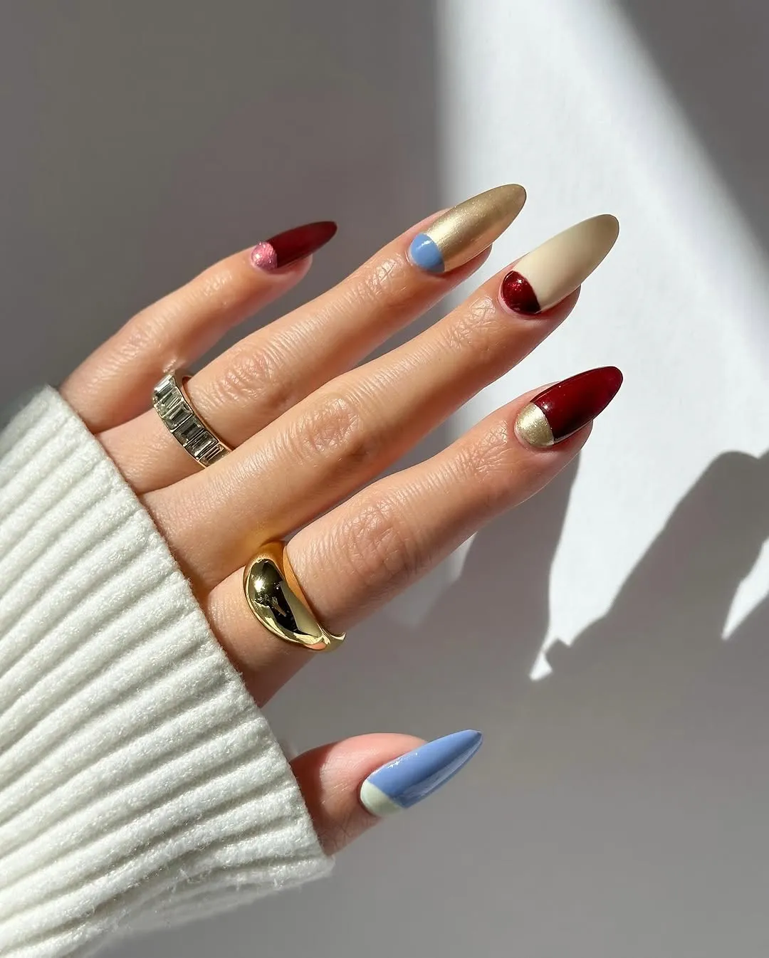 Multicolored red, gold, and light blue nails