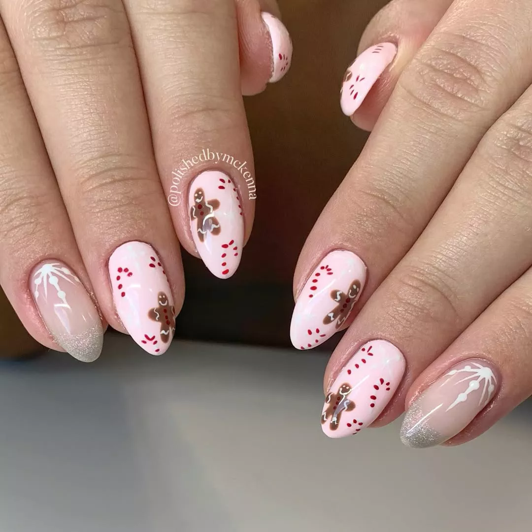 Pink manicure with candy canes, gingerbread men, and snowflakes