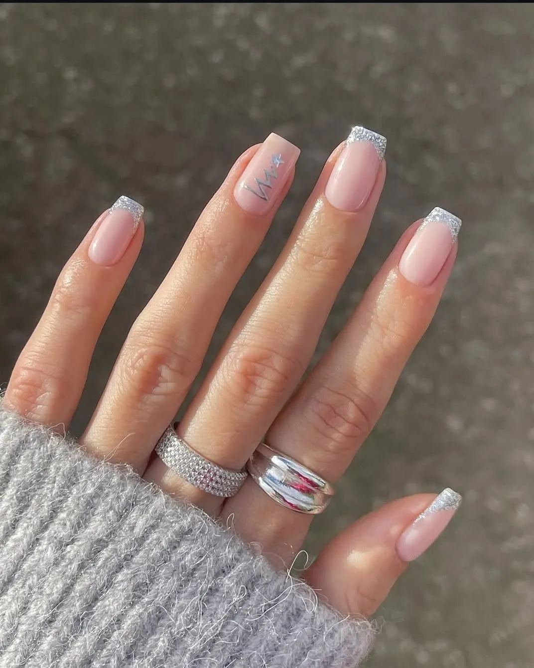 Silver Christmas nails with French tips and an abstract tree detail.