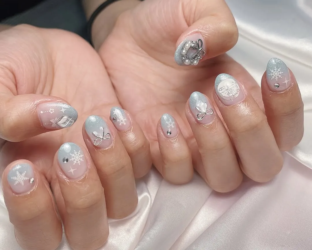 Pink and blue ombre snowflake nails with pearl accents.