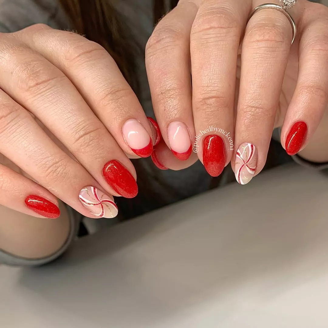 A manicure with red nails, red french tips, and peppermint swirl accent nails