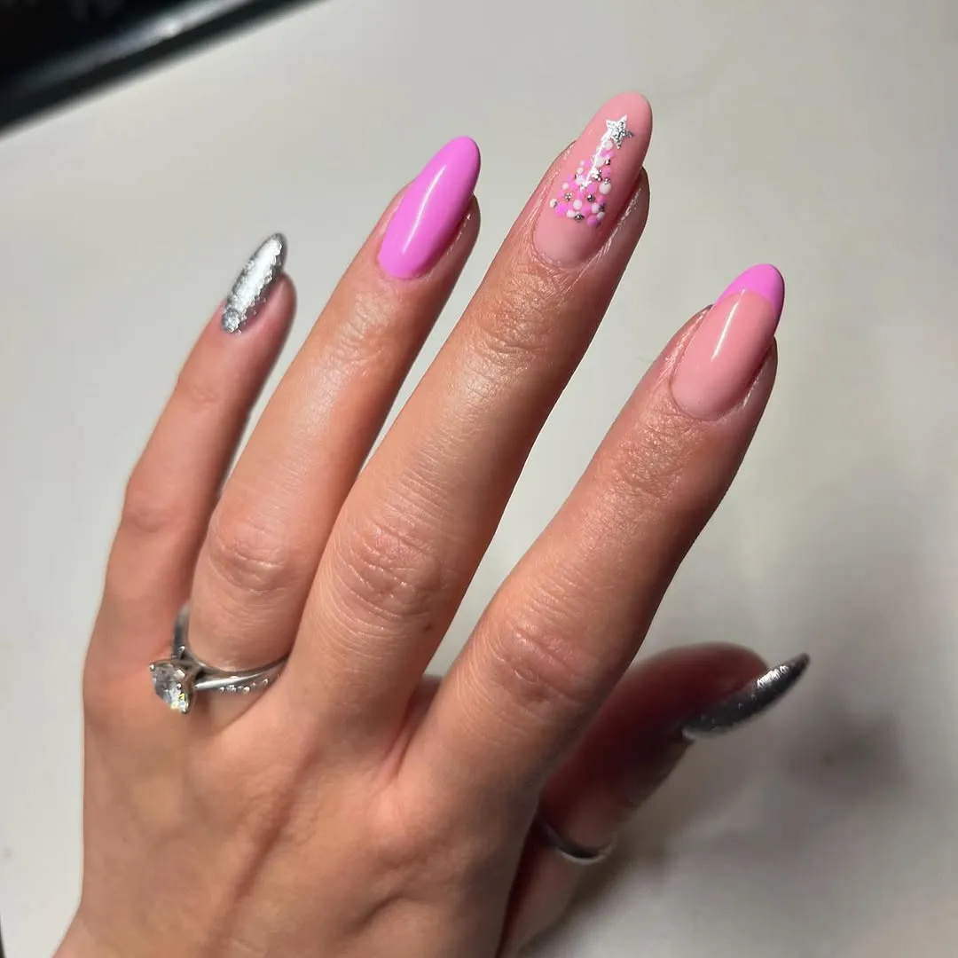 A manicured hand with long polished fingernails featuring various decorative designs