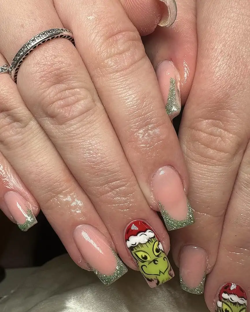 Glittery green French tips and nail art of the Grinch.
