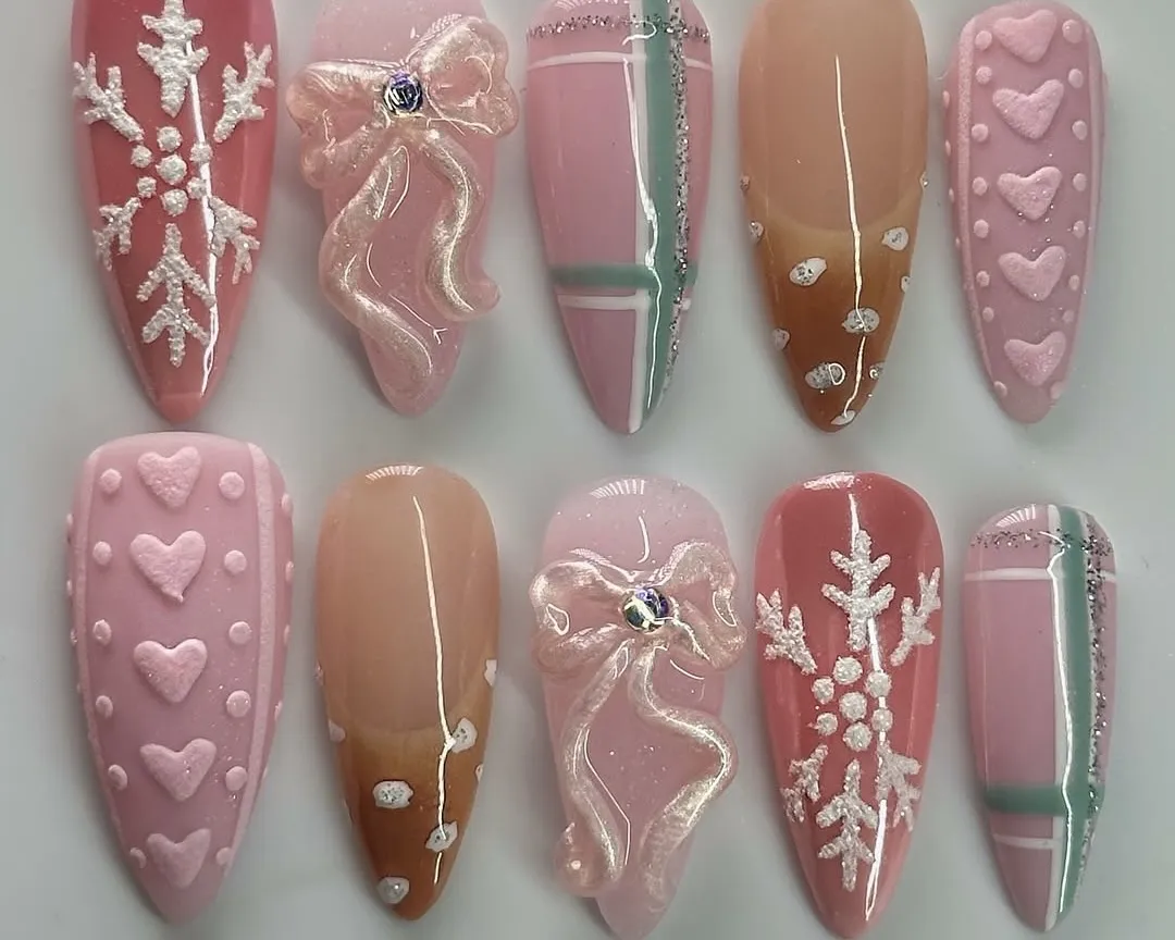 3D snowflake press-on nails with pink bows, hearts, and plaid.