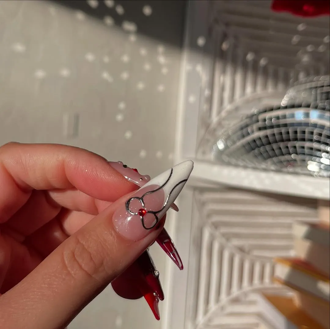 Closeup of a hand with nail art featuring floral designs