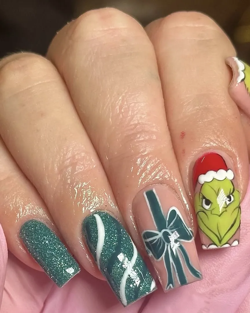 Glittery teal nails with Grinch nail art.
