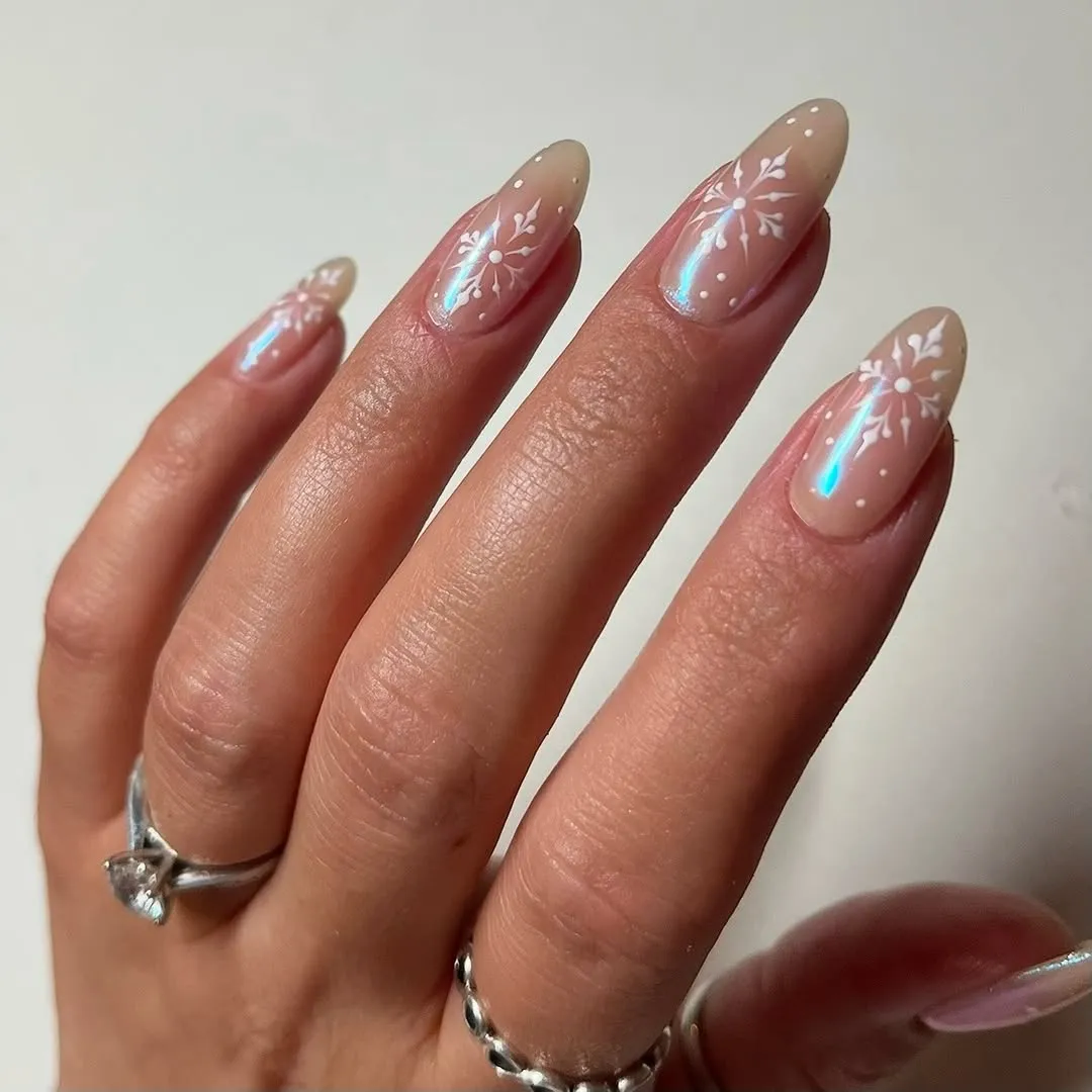 Nude nails with icy blue chrome and white snowflake accents