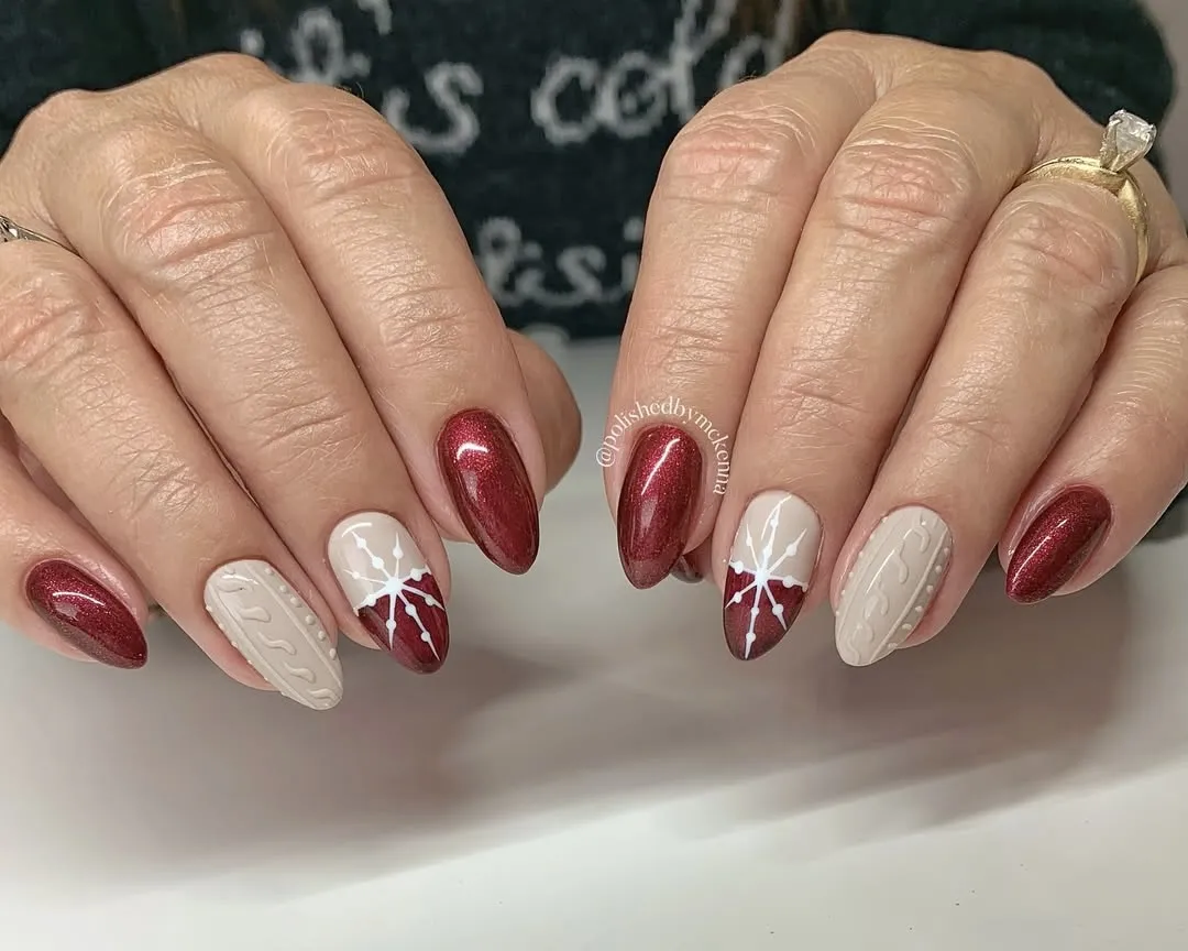 Red and cream snowflake nails with sweater and red glitter accents.