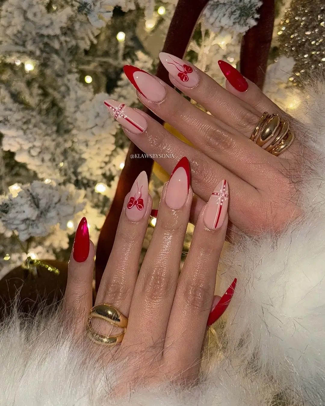 Closeup of manicured hands with festive nail art featuring red accents and holidaythemed designs against a decorated background