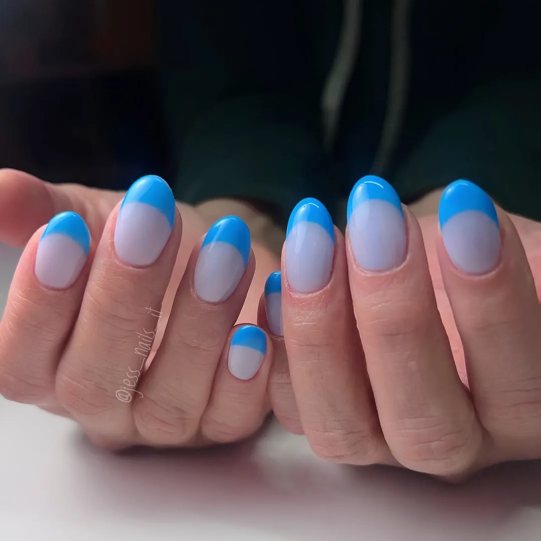 Hands showing manicured nails with a distinct blue French tip design