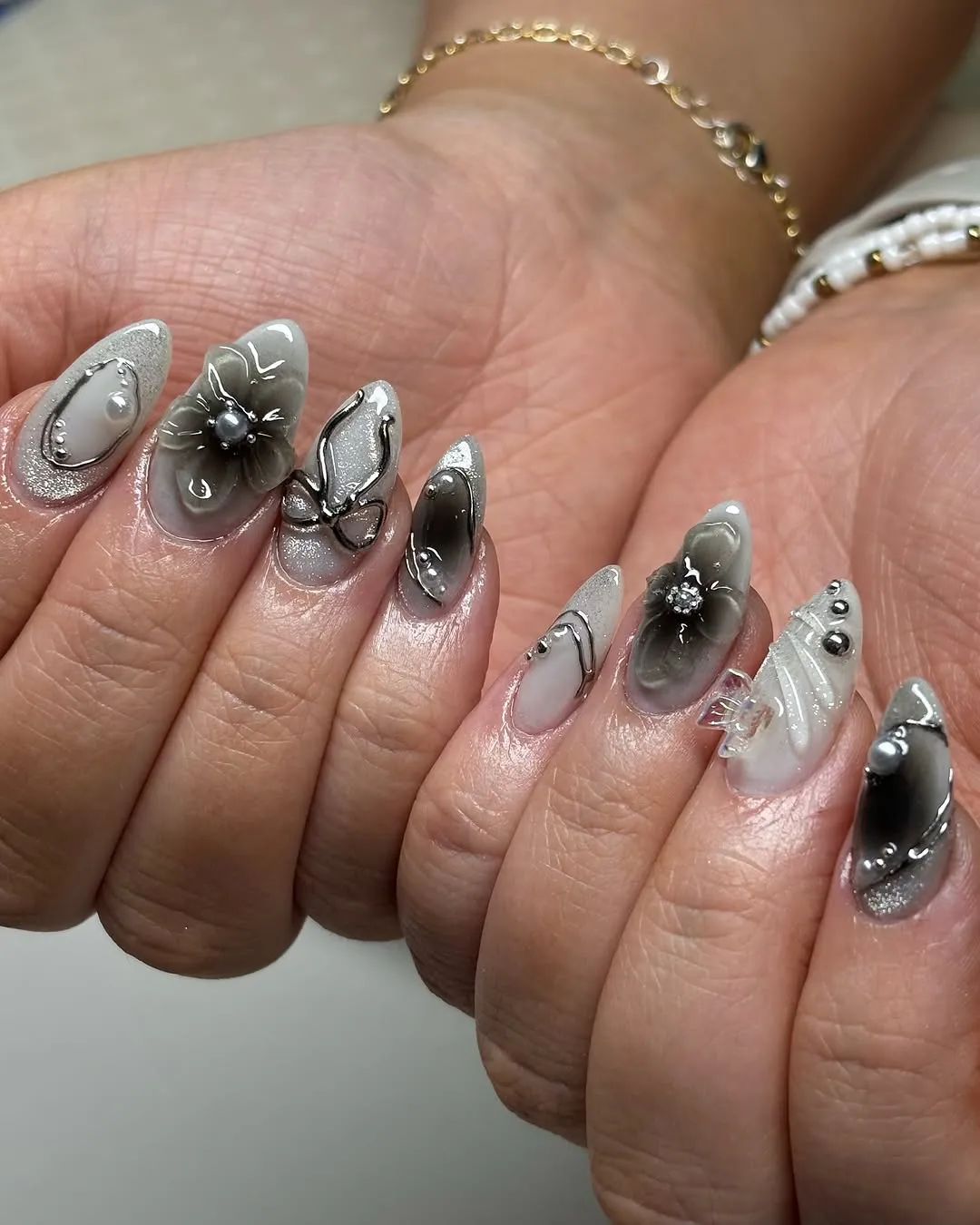 Gray and silver nails with bows and flower embellishments
