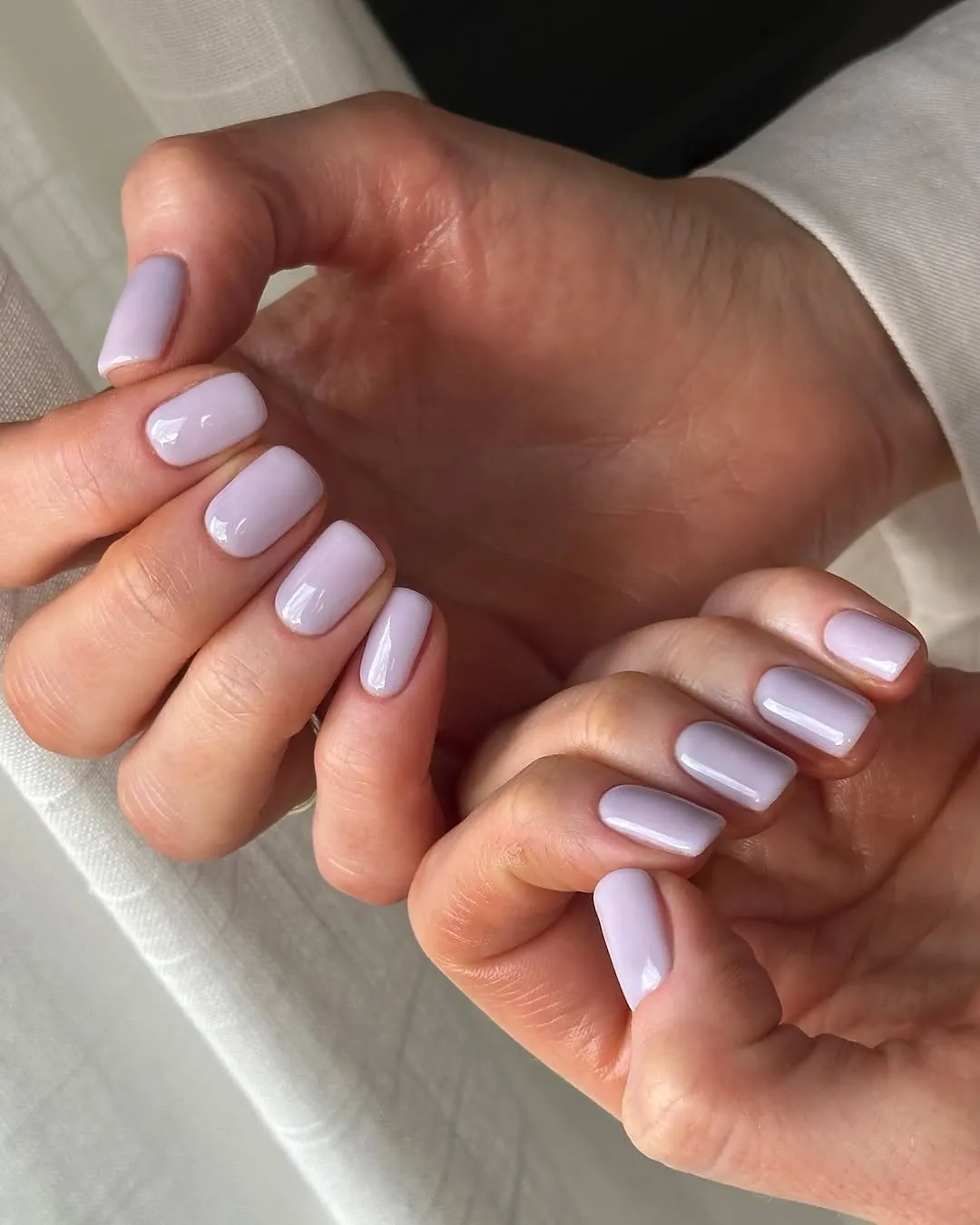 Short square nails painted a milky lavender shade