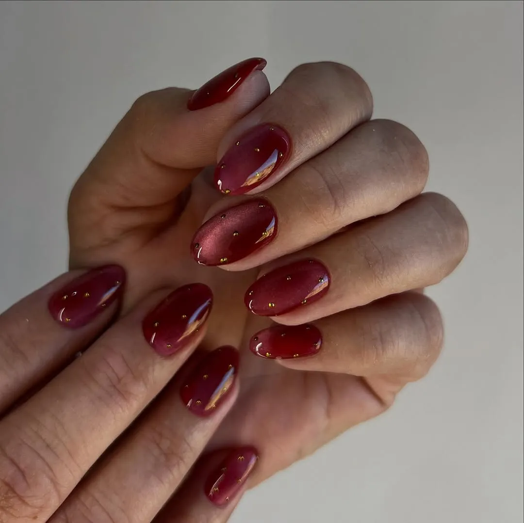 Red cat-eye nails with gold polka dots