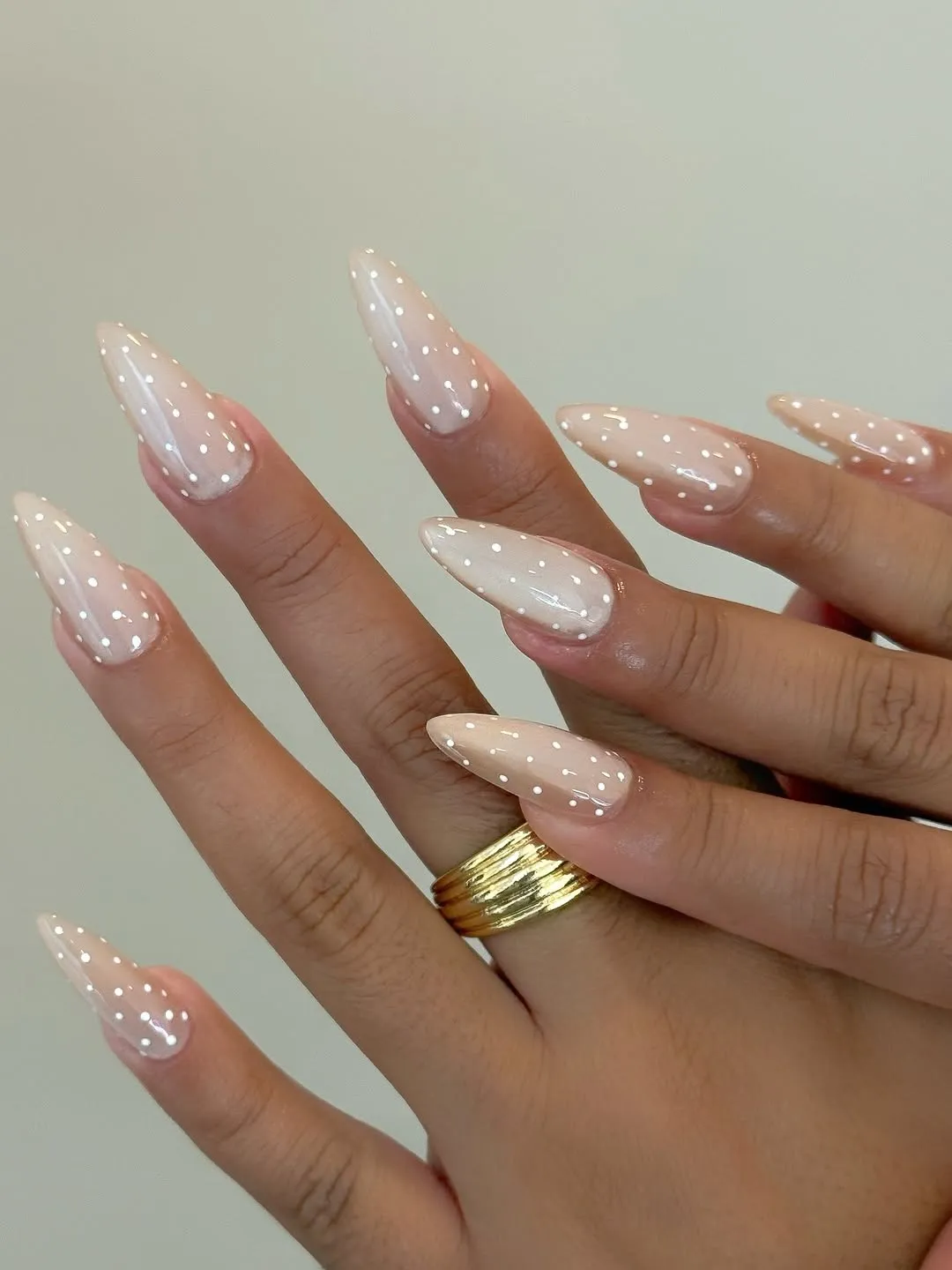 White cat-eye nails with white polka dots