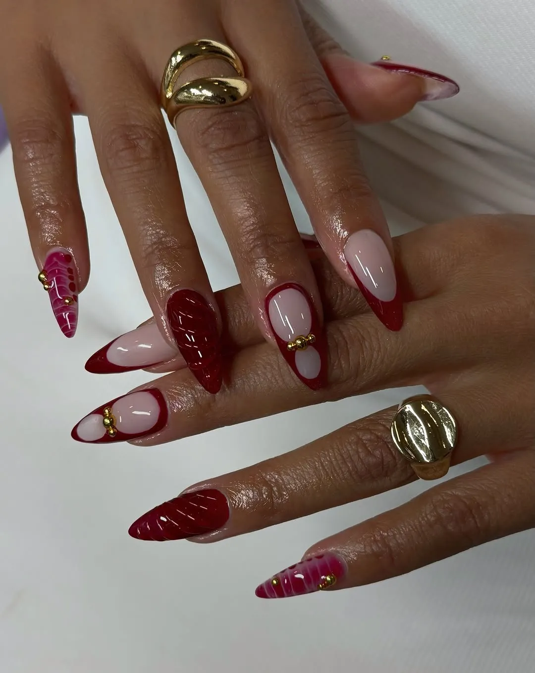 Hands with decorated long red nails and gold rings