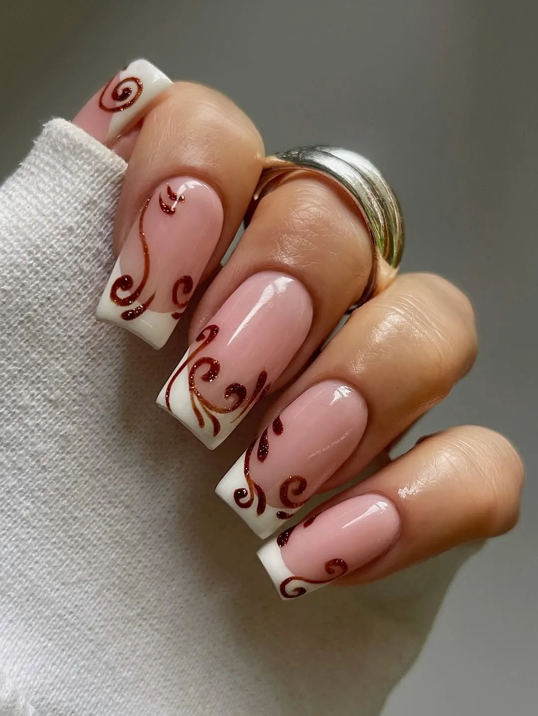 Pink French manicure with red swirls