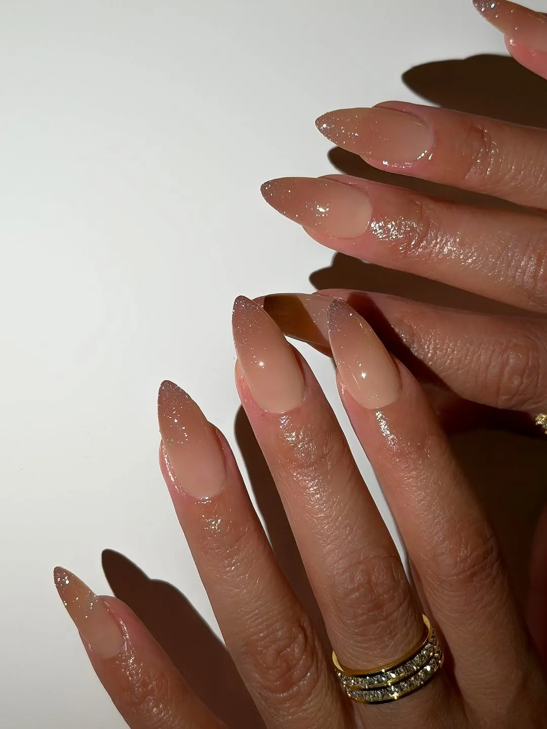 Wellmanicured hands with pointed fingernails displaying a glossy finish