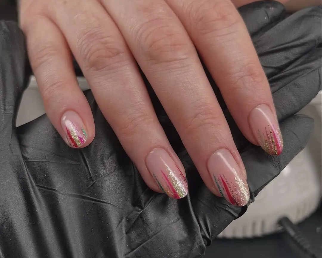 Nails featuring multi-colored stripes from the tip down in red, green, and glitter.