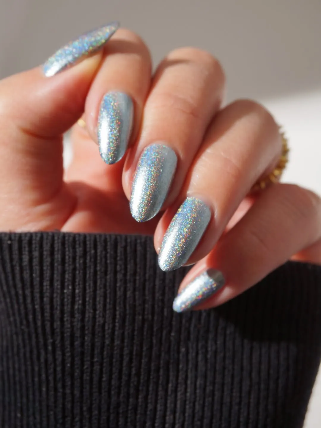 A closeup of a hand with metalliccolored manicured nails