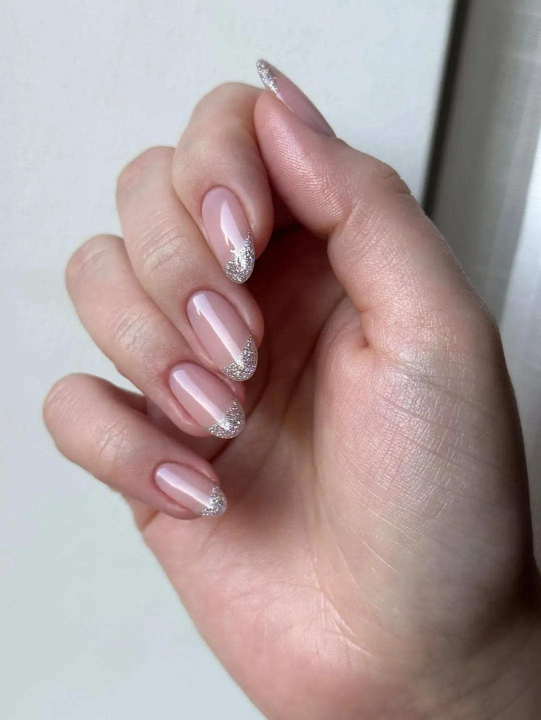 Nude nails with silver glitter French tips