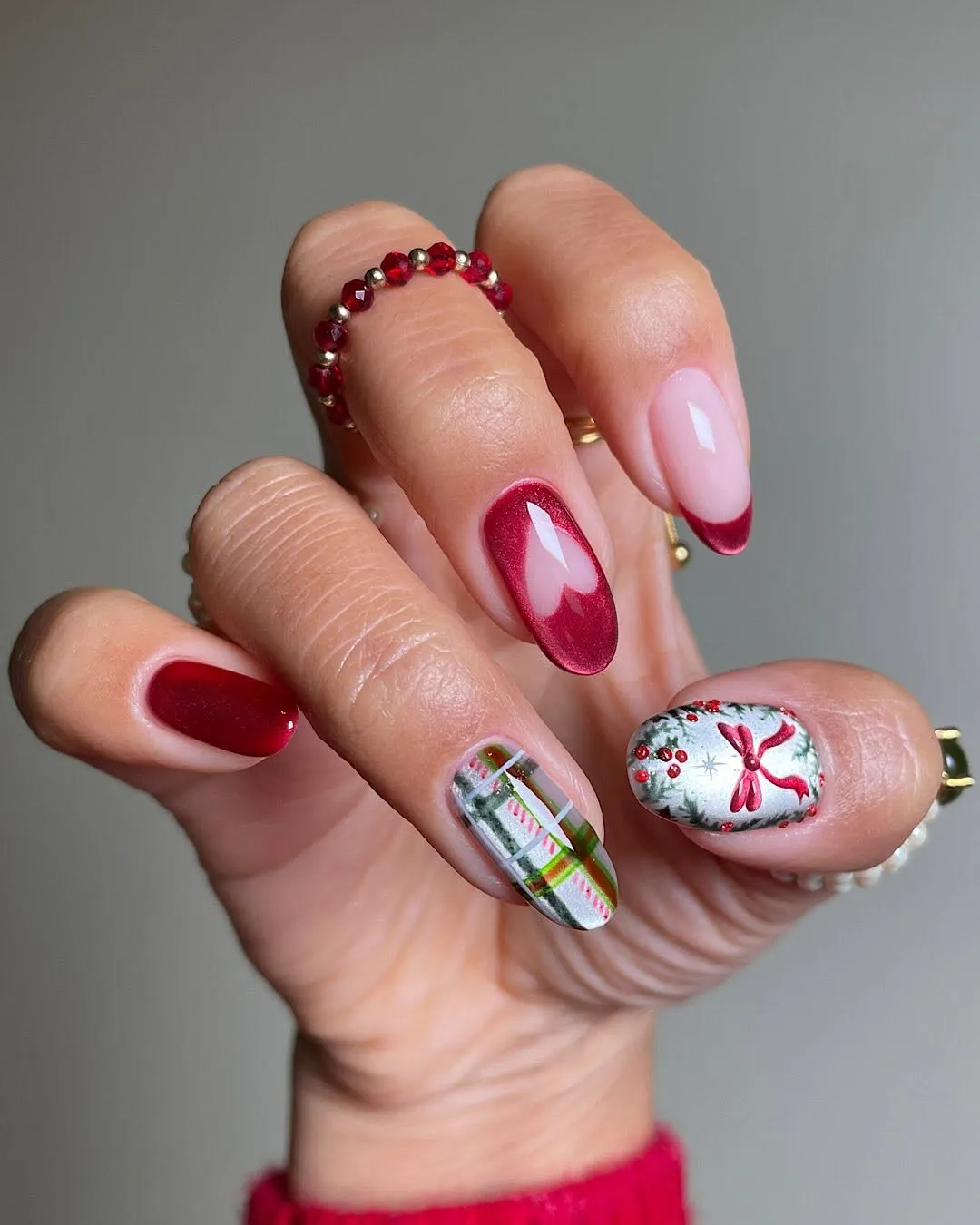 Closeup of a hand showing manicured nails with holidaythemed nail art designs