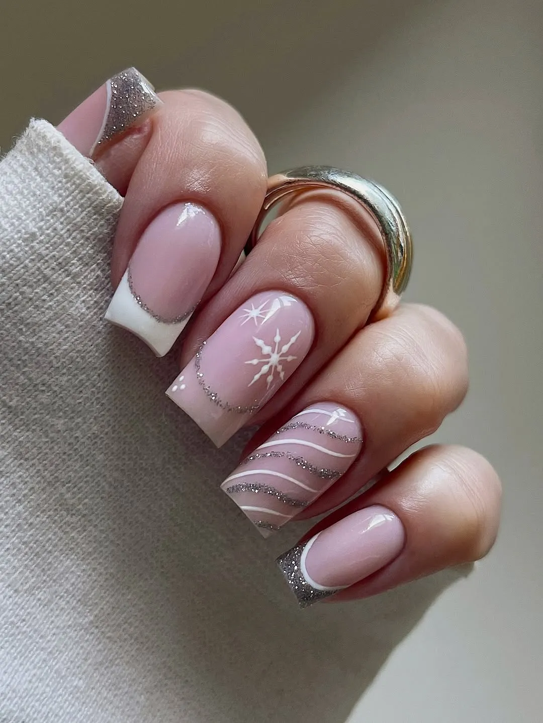A hand with manicured nails featuring an intricate design including a star and stripe patterns