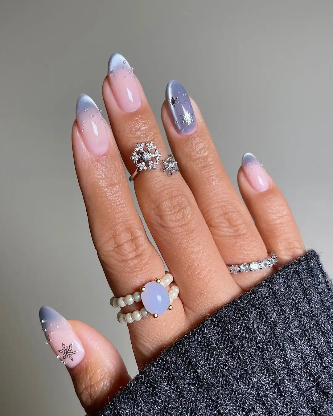 Hand with decorated nails and rings shown closeup