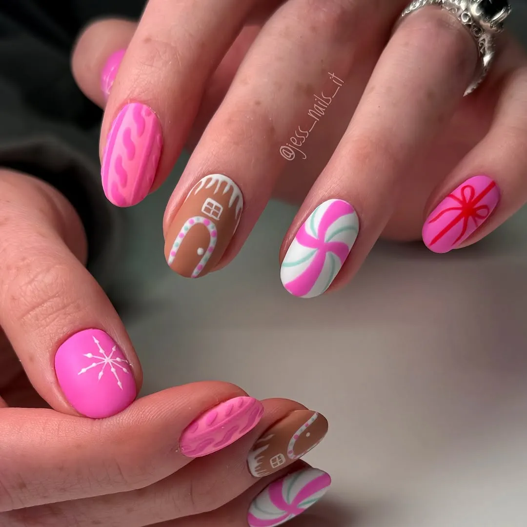 Closeup of decorated nails with holidaythemed designs including candy canes and a gingerbread house