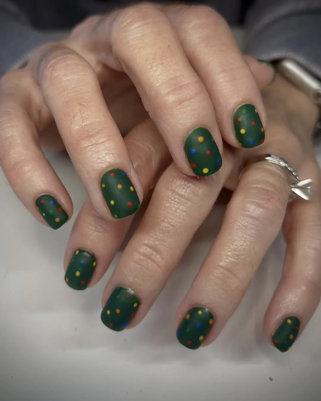 Green and rainbow polka-dot Christmas nails.