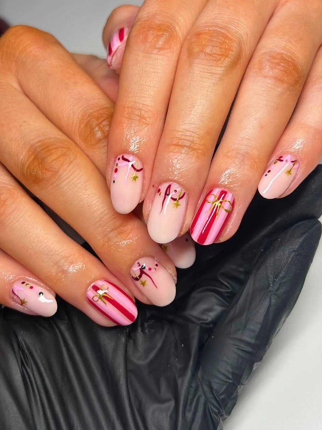 Closeup of hands showing a manicure with intricate nail art designs including stripes and accents