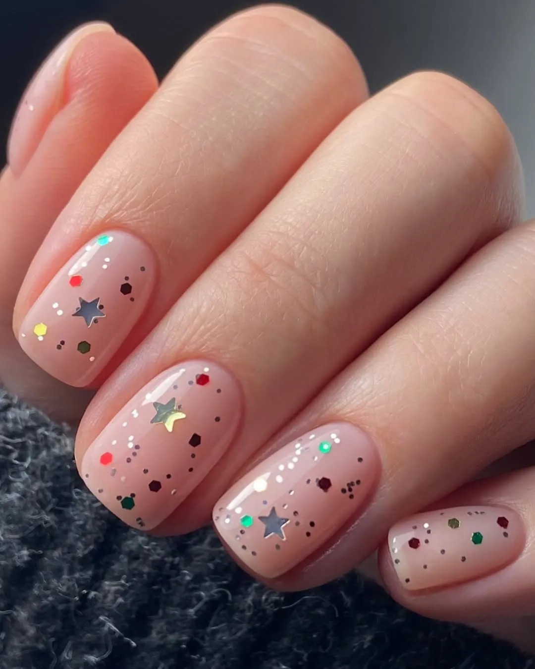 Short nude nails covered in multicolored glitter