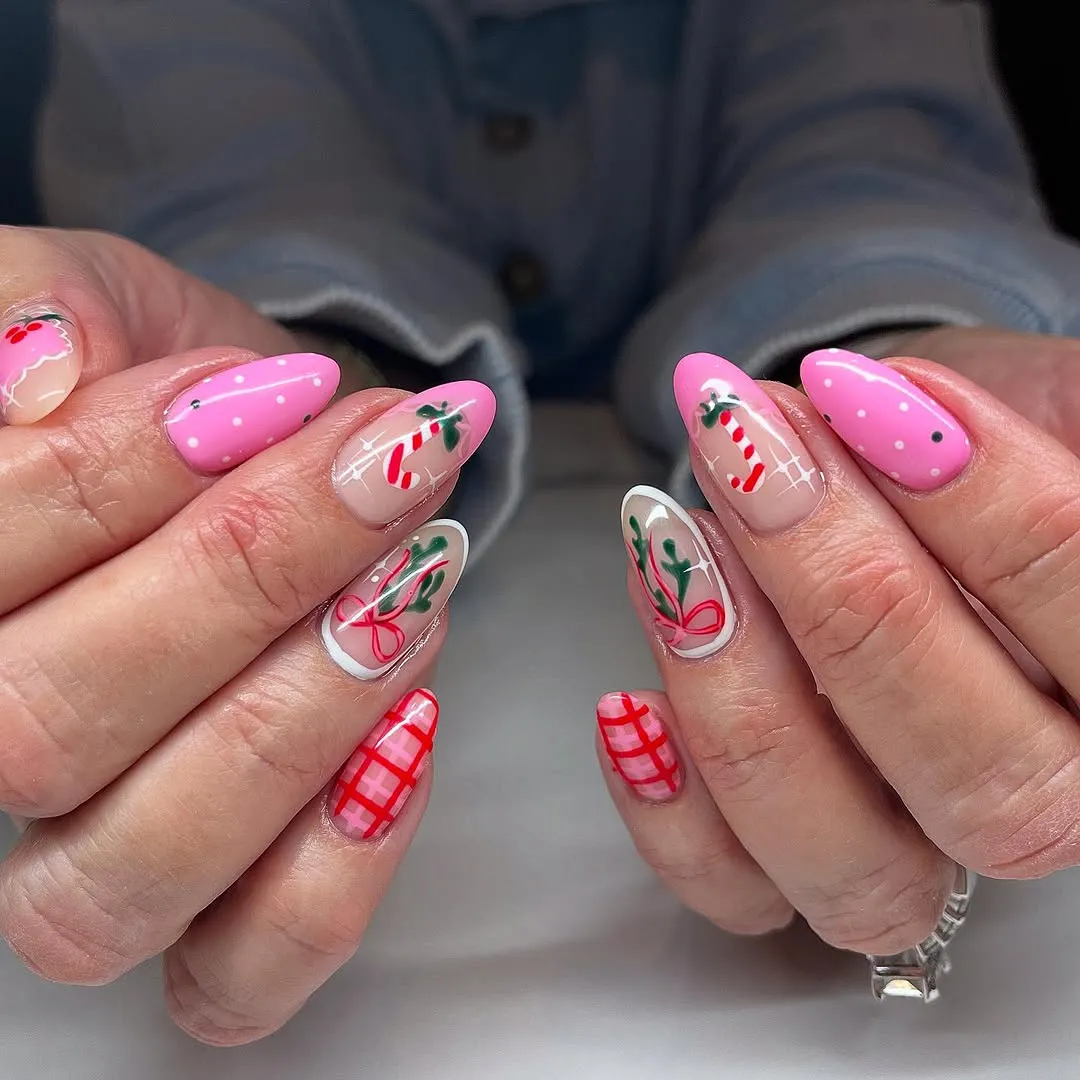 Closeup of hands with painted holidaythemed nails featuring candy canes and festive patterns