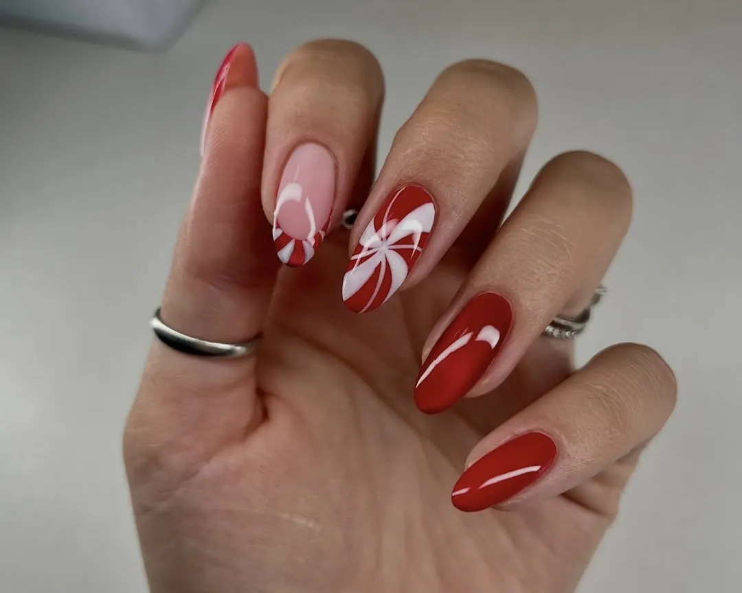 Red manicure with a peppermint swirl accent nail and accent French tip.