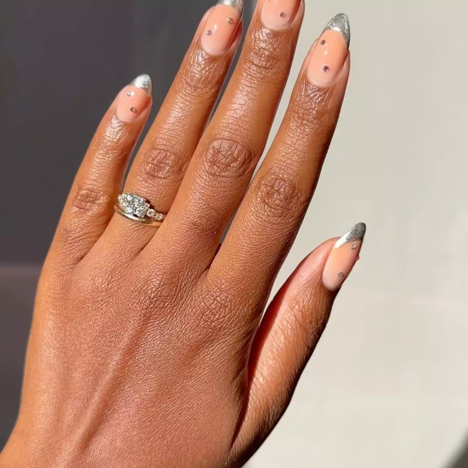 Silver almond-shaped French manicure with rhinestone accents