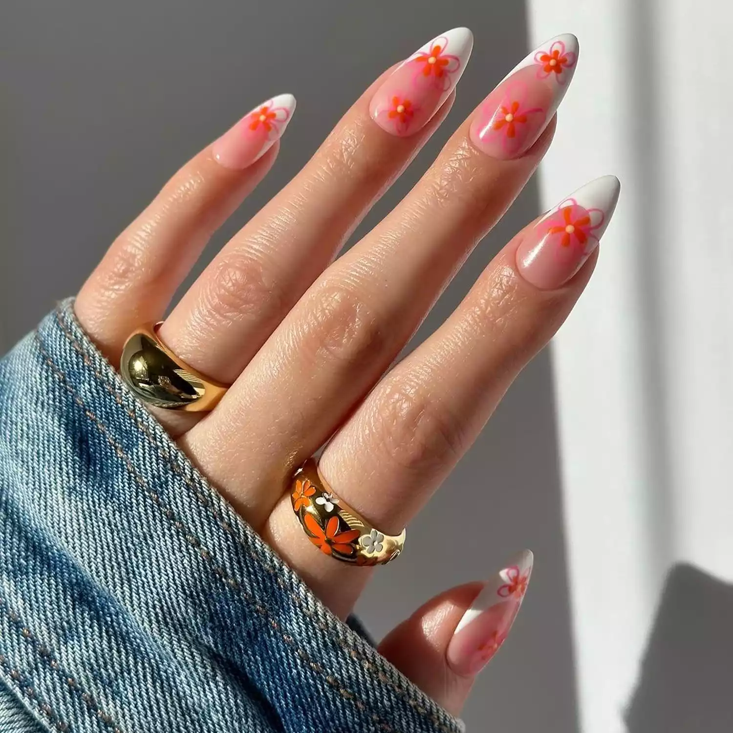 White French manicure with coral and pink flower nail art on almond-shaped nails