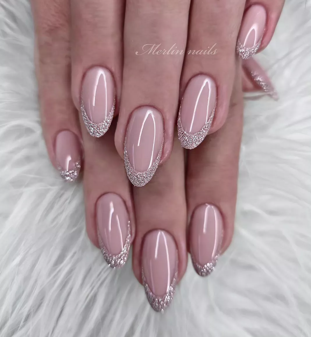 Person shows off their dusty rose nails, which have deep, glittery, pink French tips