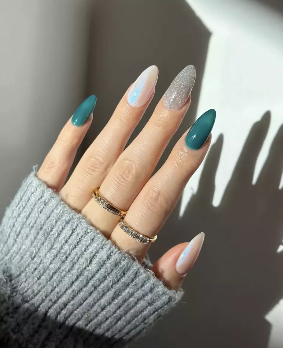 Person shows off their teal, pearl, and silver almond-shaped nails