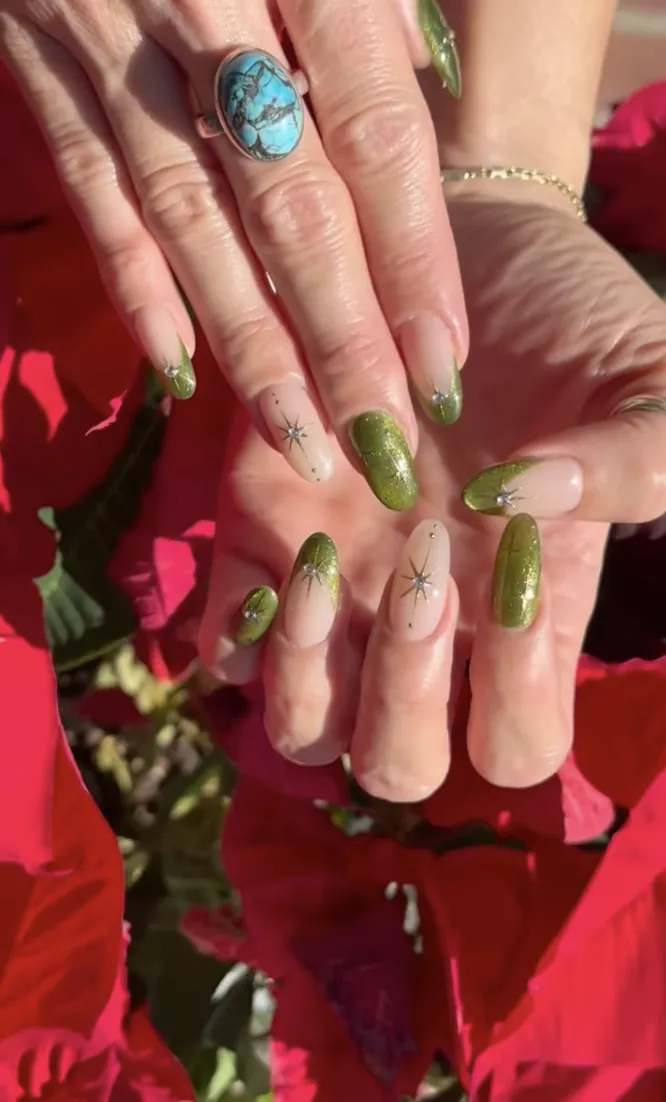 Hands with green decorated nails and a turquoise ring